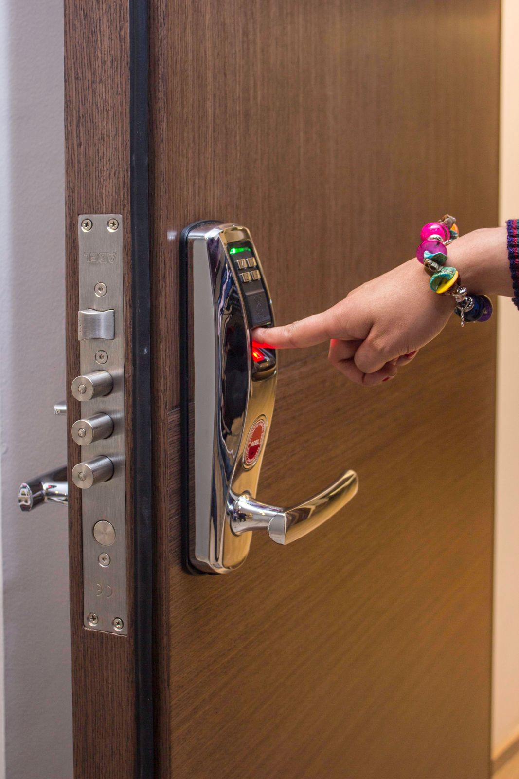 Polished chrome fingerprint lever lock with multi-bolt door edge on a wooden door