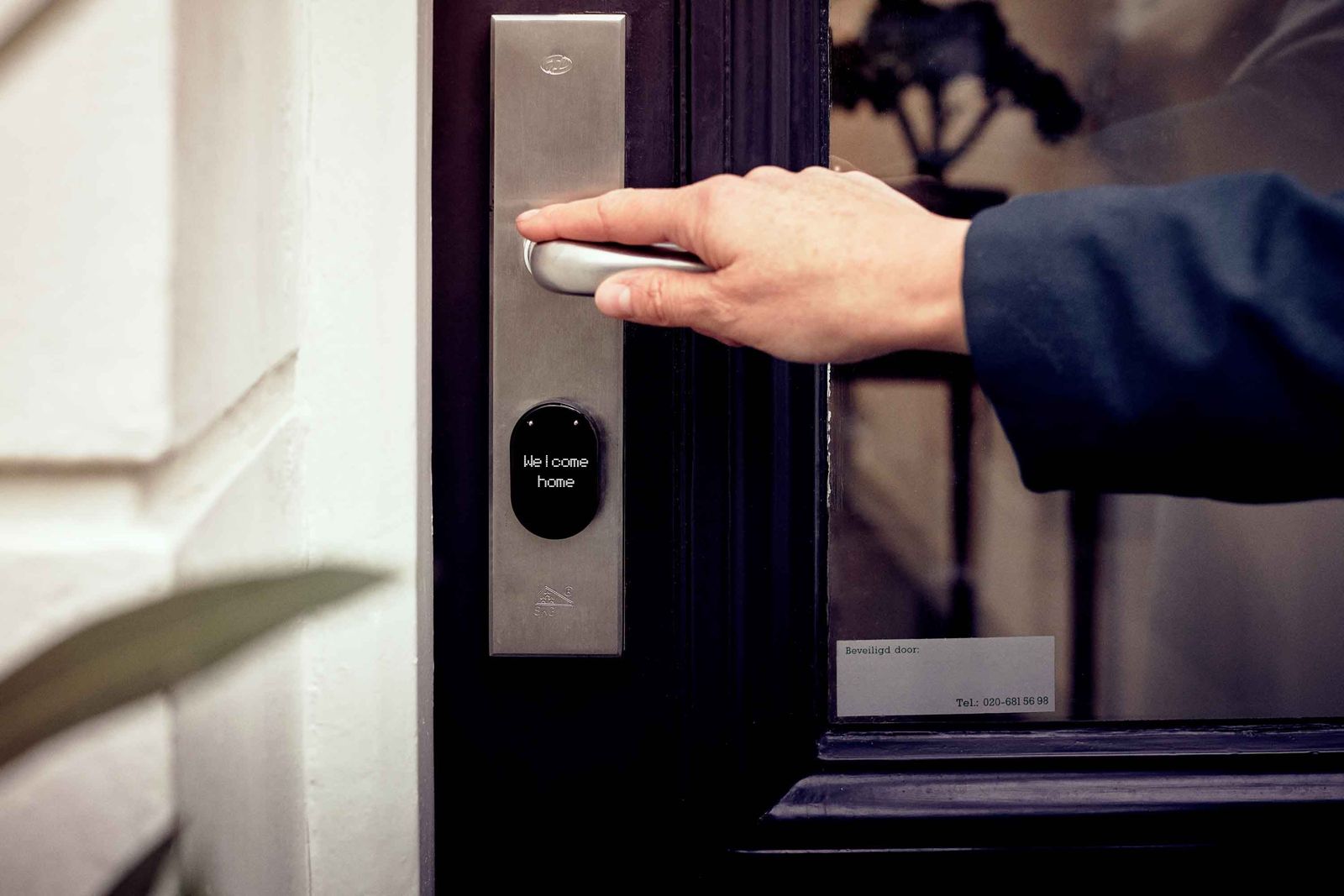 Steel handle plate smart lock with small black display reading Welcome home