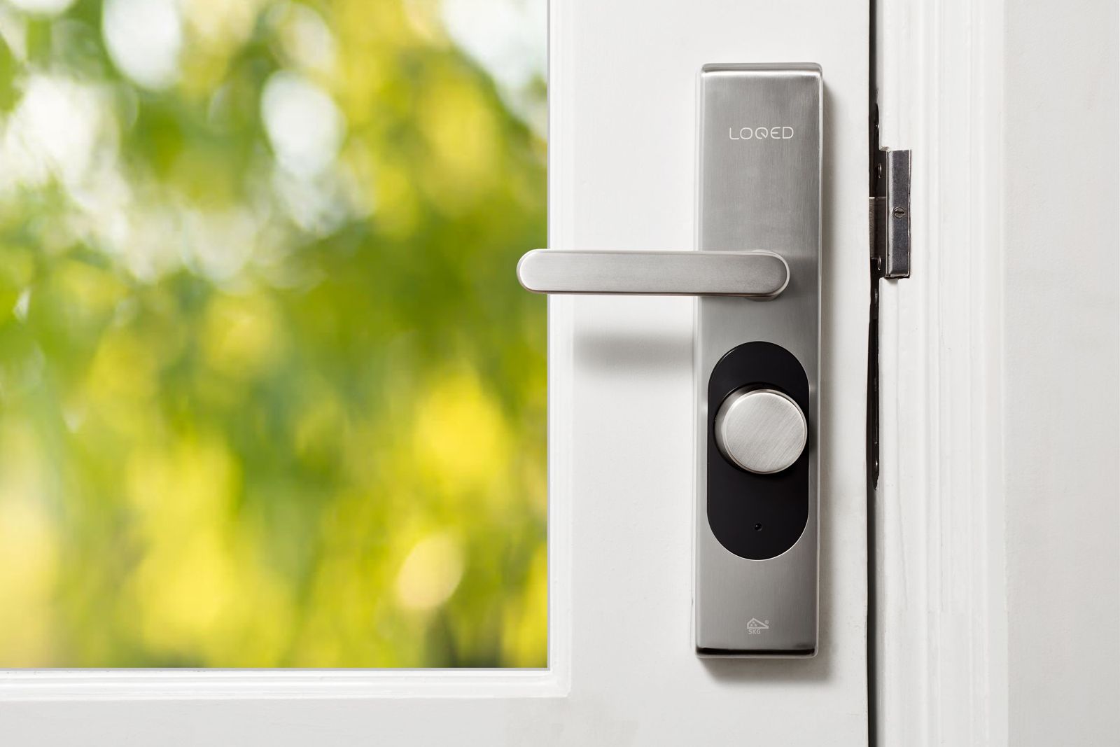 Brushed stainless smart lock with lever handle and round turn knob in a black panel